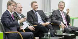 Prof. Henrik Müller, Peer Steinbrück, Christian Lindner und Udo Dolezych sitzen nebeneinander auf Stühlen.