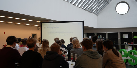 Schüler:innen richten den Blick auf eine Leinwand 