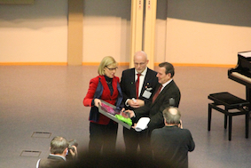  Prof. Dr. Ursula Gather, Prof. Dr. Andreas Liening und Bundeskanzler a.D. Gerhard Schröder stehen im Audimax bei der Urkundenüberreichung zum Neujahrssymposium 2012. 