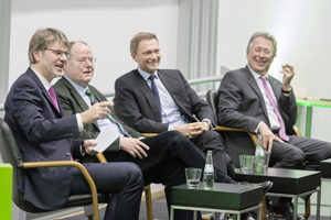 Prof. Henrik Müller, Peer Steinbrück, Christian Lindner und Udo Dolezych sitzen nebeneinander auf Stühlen.