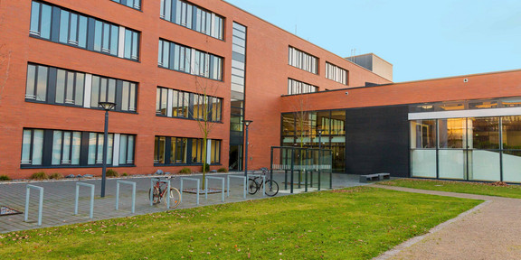 A large red building with green grass in front of it.