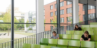 Studierende im Hörsaal Drei Studierende sitzen im Hörsaal.